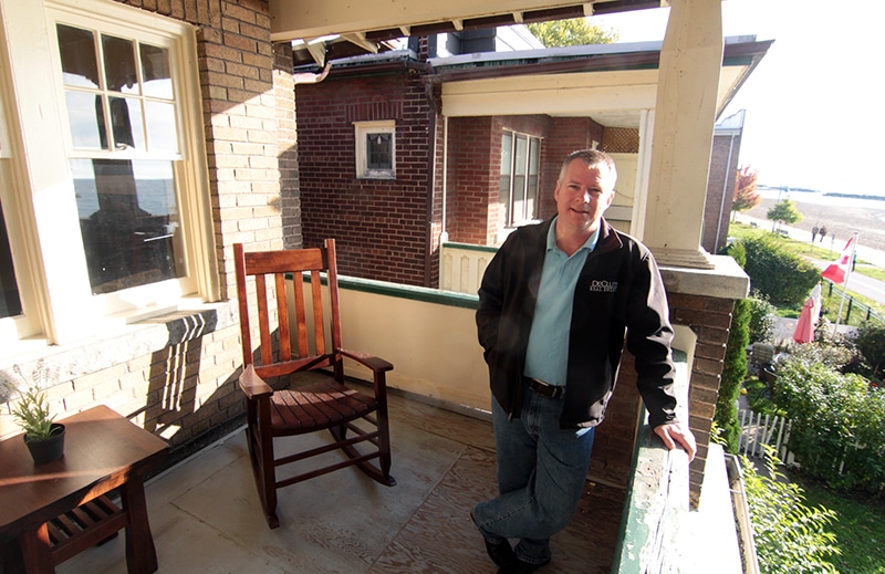 Rick De Clute, an agent with De Clute Real Estate, stands on the second-floor verandah on the beach-front heritage home at 7 Hubbard Boulevard. PHOTO: Andrew Hudson