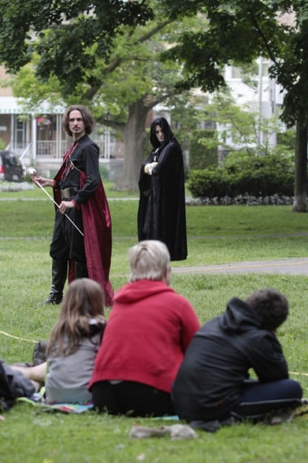 Sword drawn, the villain Iago (played by James Soares-Correia) plots while the disguised Roderigo (Jonathan Dufour) looks on during the opening night performance on June 11 in Norwood Park. PHOTO: Andrew Hudson