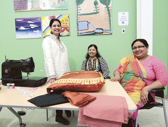 From left, Lucky Nessa, Protima Sarker, and Jamee Ara Hosne of the Dunia Design Collective at the AccessPoint community centre on Danforth Avenue. From everyday shirts and skirts to laptop covers, pillows, even wedding dresses, the women at Dunia Design Collective can design and sew it all. Designer Lucky Nessa described the group’s style as a hybrid of contemporary Western and Bangladeshi styles. While they show finished pieces at craft fairs and community events, most of Dunia’s work is custom-made. Working Saturdays from the AccessPoint centre at Danforth and Victoria Park, all the women in the three year-old collective learned to design and sew in Bangladesh. Home to some of the world’s best cotton, and muslin so fine that “a whole saree can pass through a ring,” Bangladesh also has a strong tradition of home designers that has the effect of turning thousands of families into competing fashion houses. To learn more or to place an order, email duniacollective@gmail.com. PHOTO: Andrew Hudson