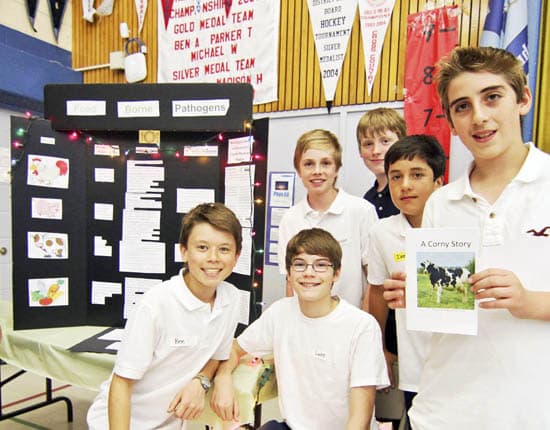 From left to right, Grade 8 students Ben Ing, Luke Dolenc, Jackson Hickey, Jack Doyle, Daniel Olivia and Michael Turner stand by their exhibit on food borne pathogens at the St. John Catholic School food symposium on May 29. Along with posters geared toward older students and visiting parents, Olivia and Turner wrote, "A Corny Story" about a cow whose digestive system becomes a place for bad bacteria like Larry Listeria and Sammy Salmonella to party after her farmer switches her to an all-corn diet that is too low in fibre. PHOTO: Andrew Hudson