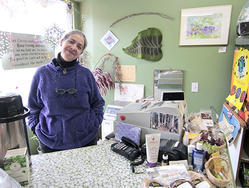 Ellen Godfrey, who opened Loving Nature Natural Foods 10 years ago at Kingston Road and Victoria Park Avenue, greets customers on Jan. 8 with a fresh pot of peppermint tea on the counter and a batch of favourite recipes behind it. PHOTO: Andrew Hudson