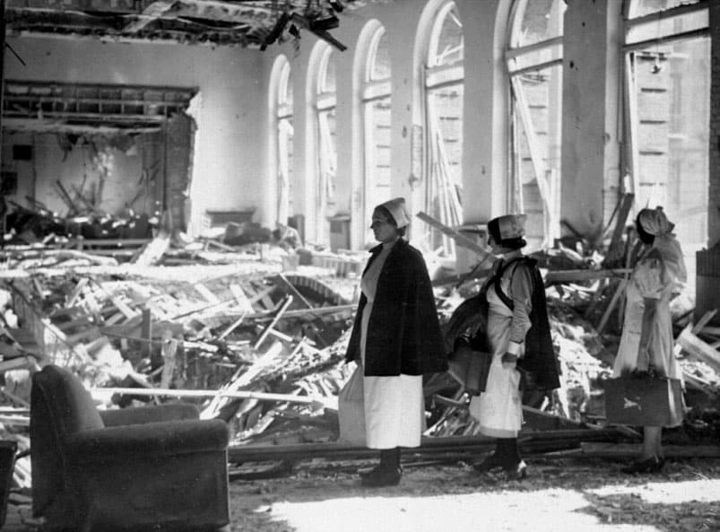 Nurses survey bomb damage at the Manchester Royal Infirmary nurses’ residence. Veteran Jean Eade was outside when she saw a buzz bomb hit the building on October 11, 1940. “For a couple of seconds, the wall was there, and then – it was like a movie,” she said. “The wall came out and you could see all the rooms.” Photo courtesy Central Manchester University Hospitals NHS Foundation