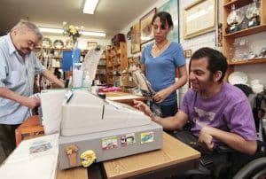 Chris, a Pegasus participant, rings up the till for a customer while staffer Rose Leask looks on. At the Pegasus thrift store on Kingston Road, participants gain work experience while helping raise funds for the program. PHOTO: Andrew Hudson