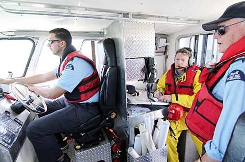 Pickering Auxiliary Rescue Association members Adrian Anwar, left, Colin Thompson and Michael Leahy, far right, prepare for a rendezvous with the 424 Transport and Rescue squadron helicopter on July 13. PHOTO: Andrew Hudson