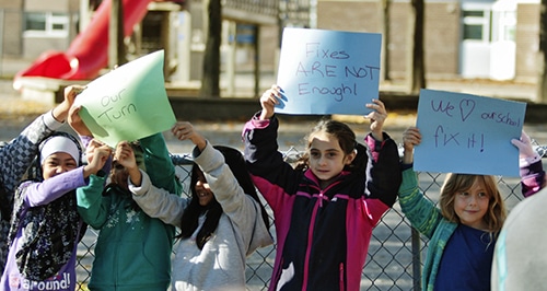 Students hold up signs protesting the poor conditions in the aging portables at Secord Elementary School on Friday, Oct. 24 after their parents removed them from class in a one-day walkout. PHOTO: Andrew Hudson