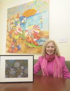 Painter Lynda Freeman shows off one of the works she will exhibit at the Beach Guild of Fine Art’s Small Paintings for Small Spaces show. Another is shown at left. The oil pastel drawings point in a different direction than her usual figurative work, such as the painting on the wall of her Upper Beach kitchen studio, above. PHOTO: Jon Muldoon