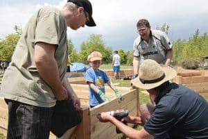 Five-year-old carpenter Jude, centre, holds a cedar board in place as volunteers with the Friends of the Beach Parks build raised garden beds for the Beach Community Edible Garden on May 30. With garden beds that will provide fresh produce for a food bank and a youth cooking class run by the Beaches Rec Centre, the community garden will also include veggies for public snacking and plants for bees, butterflies and other pollinators.  PHOTO: Andrew Hudson